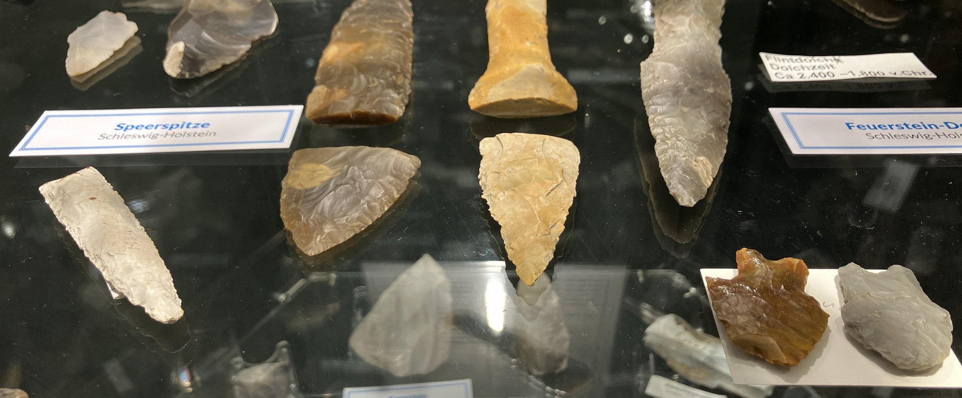 Das Foto zeigt steinzeitliche Werkzeuge im Eiszeit-Haus. Es sind verschiedene Pfeil- und Speerspitzen zu sehen.