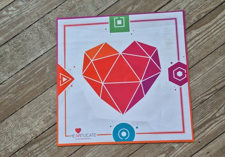 Mit einer Matte auf dem Fußboden geht es los. Die Matte trägt das Logo der Lernplattform Heartucate. Die Plattform entwickelt AR-Erlebnisse und Begleitmaterial für den Bildungsbereich. Mit Hilfe der Matte können zeitgleich vier Spielende in einen virtuellen Escape Room in der Arktis reisen.