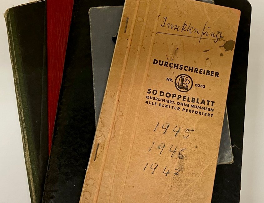 Auf dem Bild ist ein Stapel alter Hefte zu sehen. Obenauf liegt ein Heftchen, dass mit „Insektenfänge 1945 – 1946 – 1947“ beschriftet ist.