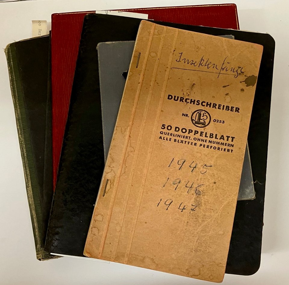 Auf dem Bild ist ein Stapel alter Hefte zu sehen. Obenauf liegt ein Heftchen, dass mit „Insektenfänge 1945 – 1946 – 1947“ beschriftet ist.