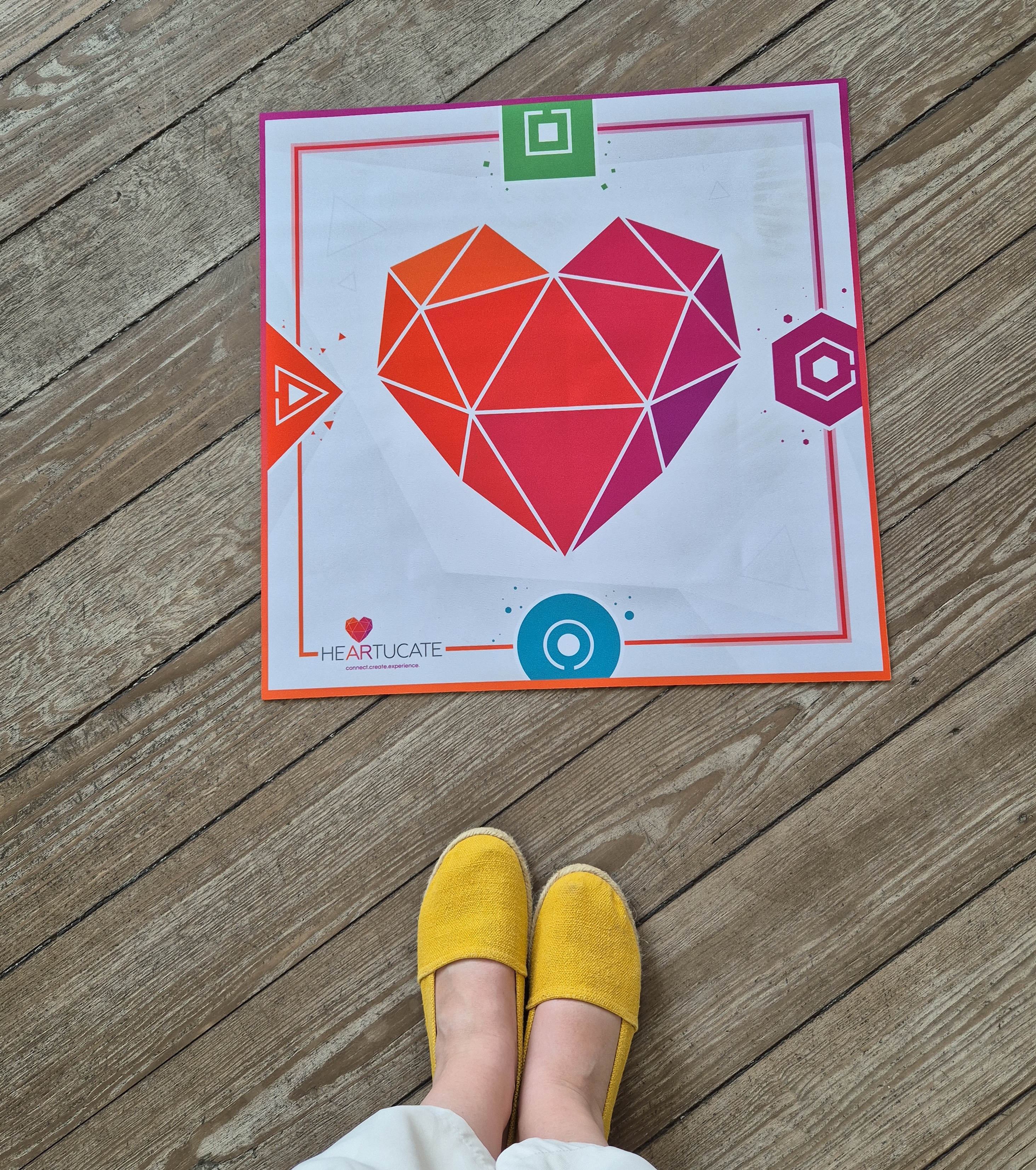 Mit einer Matte auf dem Fußboden geht es los. Die Matte trägt das Logo der Lernplattform Heartucate. Die Plattform entwickelt AR-Erlebnisse und Begleitmaterial für den Bildungsbereich. Mit Hilfe der Matte können zeitgleich vier Spielende in einen virtuellen Escape Room in der Arktis reisen.