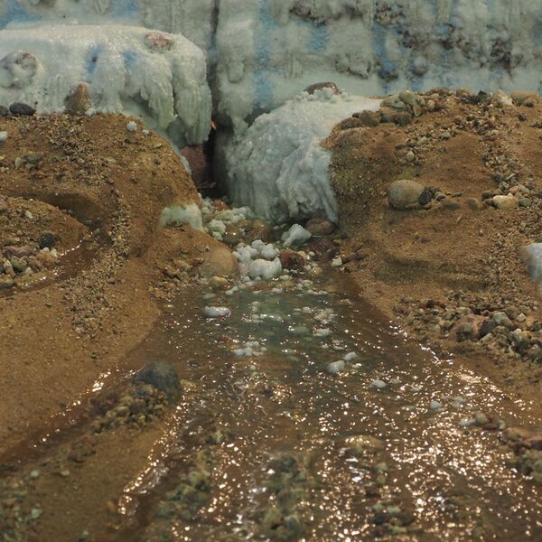 Das Foto zeigt einen Blick auf ein Gletschermodell. Der Betrachtende blockt frontal auf ein Gletschertor.